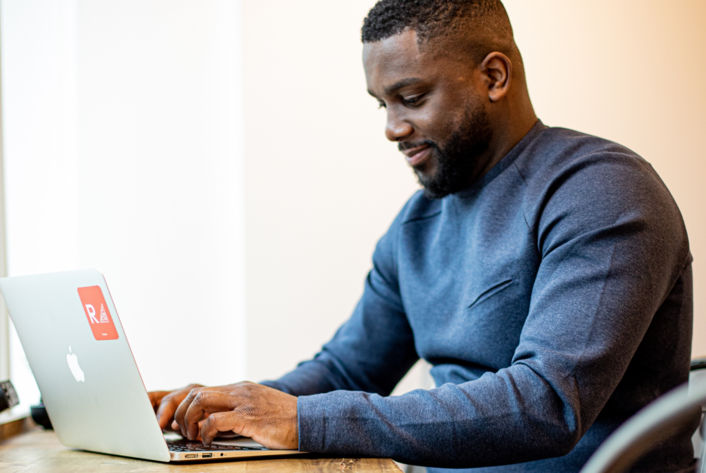 Black man software developer working on computer at desk